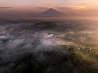 Misty Borobudur temple in the morning with the Merapi, Merbabu and Arjuno mountain in the surroundings. Borodubur is the biggest Buddhist temple in the world that was one of 7 wonders of the worlds.