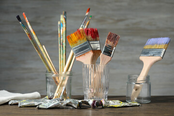 Brushes and color paints on wooden table
