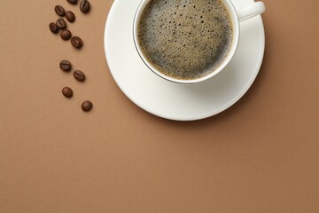 Aromatic coffee in cup and beans on beige background, flat lay. Space for text