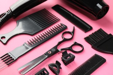 Different hairdresser's tools on pink background, closeup