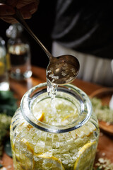 Close up of preparation of elderberry flower syrup, soft light with deep shadows.