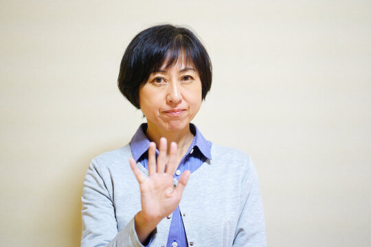 手を出して静止する中年女性