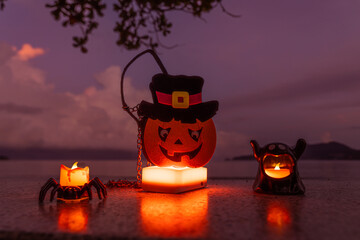 Concept: Halloween beach and ocean background with spider, witch and ghost pumpkin. Dark, scary tone.