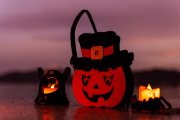 Concept: Halloween beach and ocean background with spider, witch and ghost pumpkin. Dark, scary tone.