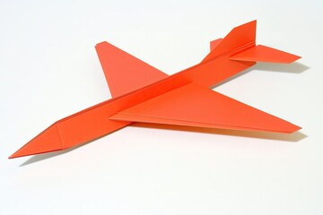 Origami airplane, vibrant orange, precise folds