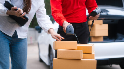 Middle-aged Asian female saleswoman delivers boxes of parcels online seller, hands packages to...