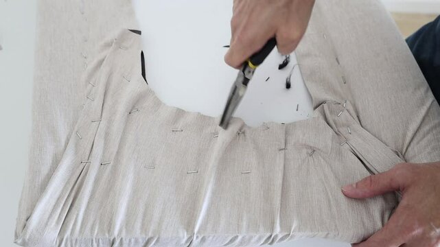 Man hands using a long nose pliers to take out staples
