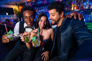 Friends taking selfie while drinking cocktails at the bar