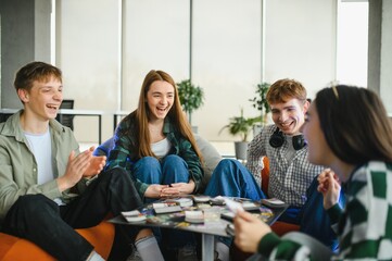 Happy friends playing board game at home, having fun together