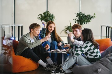 Group of young adults playing board game in modern office space