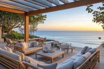 Obraz premium Luxurious outdoor lounge overlooking serene coastal views at sunset with comfortable seating and elegant decor