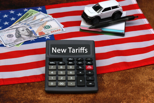 New auto tariffs in America. Flag with dollar bills and the text "New Tariffs" on the display of a calculator.