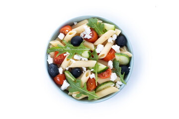 Mediterranean Pasta Salad in bowl with Fresh Vegetables and Herbs isolated on white background. Top view