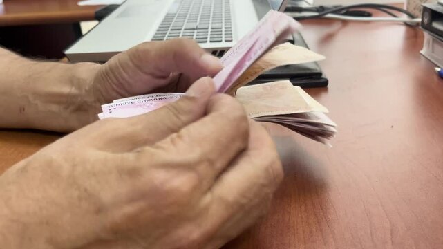 A man's hand counting Turkish Lira 