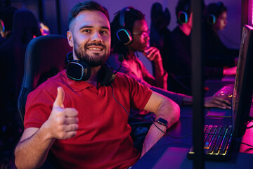 Smiling, positive facial expression. Gamers are playing video game by computers