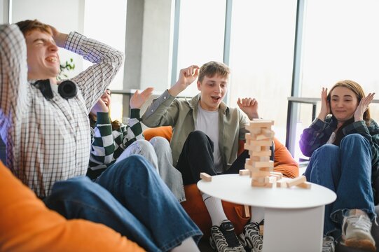 Excited friends playing skill game and having fun together - Powered by Adobe