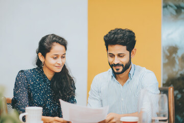 A bright conference room in an Indian corporate office with a relaxed atmosphere The mentor and intern sit together