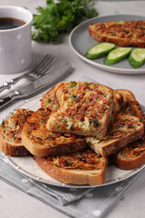 Hot sandwiches with potatoes and sausage in plate and cup of coffee on gray table