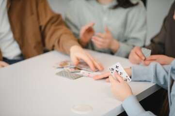 Friends playing cards at home, enjoying their free time