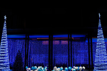 Christmas and New Year interior decoration with background, pine tree decorated with beautiful garlands of lights.