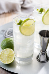 Gin Fizz cocktail with lime on wooden table