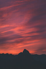 stunning and colorful sunrise over the mountains with peaks silhouettes on a vertical frame