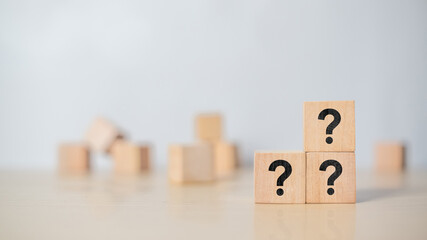 Question mark symbol on wooden cube placed on table. Idea of asking, doubt, problem solving, and...