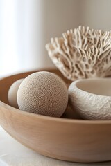 Serene natural decor featuring textured spheres and coral in a wooden bowl, creating organic coastal vibes for tranquil home styling