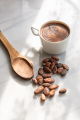 Workspace with cacao beans and hot drink