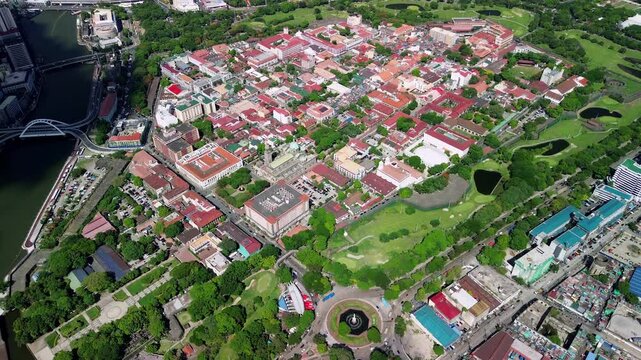 Drone captures the entire Intramuros walled district in Manila from above, revealing red rooftops, green parks, and colonial buildings in sharp sunny detail.