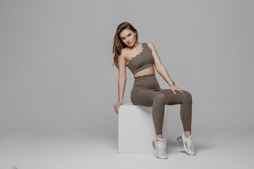 Model poses in stylish activewear on a minimalist set during a fashion shoot