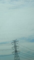 Electric Tower Under Soft Blue Sky with Wispy Clouds, Power Supply Infrastructure, Connecting Energy Systems