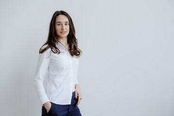 Professional young woman poses confidently against a clean white background showcasing her outfit...