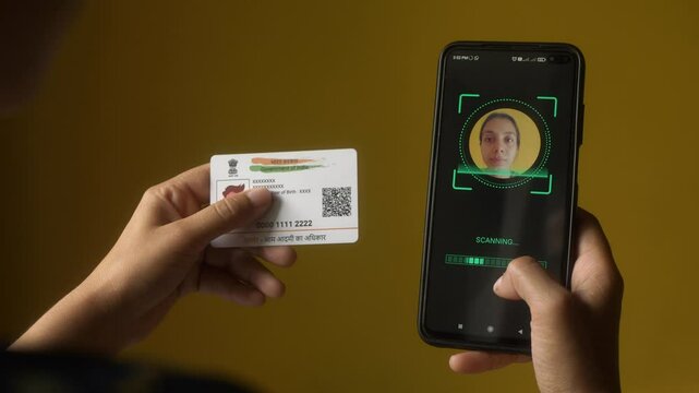 Indian nationality woman scanning her face on mobile phone for eKYC digital identity verification using Aadhaar card