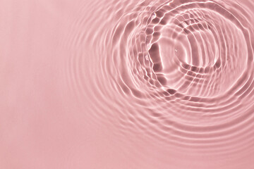 Pink water ripple texture background on the harsh light. 