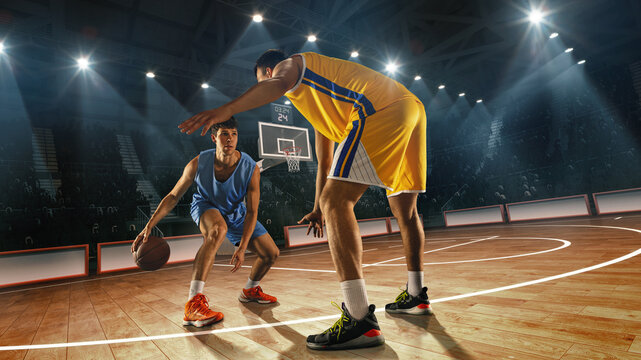 Composite collage. Basketball player in blue dribbles low, facing defender in yellow uniform on 3D basketball court with visible hoop and audience behind.