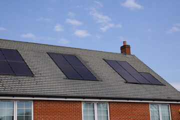 Solar power panels on roof of house in the UK. Alternative clean energy source. Photovoltaics installed on residential building 