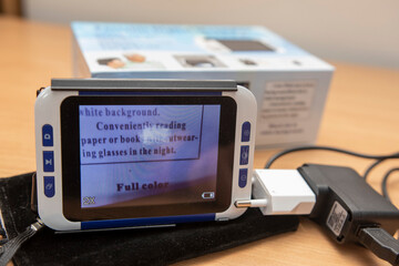 Close-up of a digital electronic magnifier used for reading assistance and low vision support on a desk