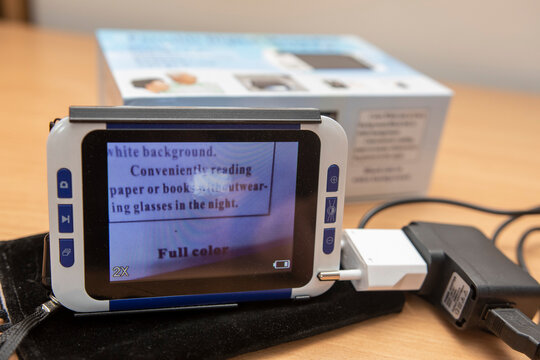 Close-up of a digital electronic magnifier used for reading assistance and low vision support on a desk