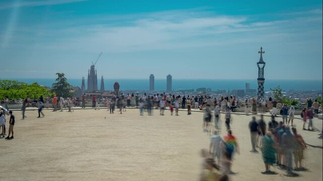 Timelapse video of tourists visiting Parc Guell park on a sunny day during tourist season. Concept of mass tourism in Spain