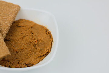 Close-up of a white plate with liver pate and bread on top on a white background with space for text. The concept of snacks, healthy food, diet. High quality photo