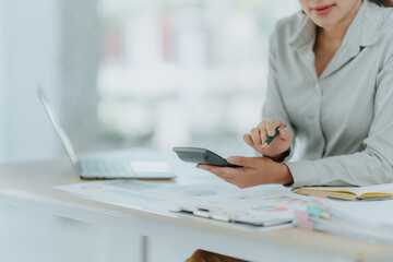 Fototapeta premium Woman Calculating Finances at Desk