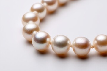 Elegant pearl necklace displaying subtle iridescence and smooth, round shapes, conveying luxury and timeless beauty on a pristine white background, a symbol of refinement.