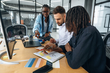 By the table with documents. Business people are working in the office