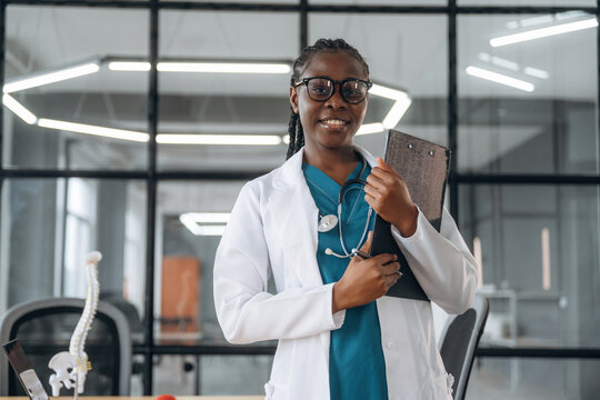 In white coat. Female doctor in coat is in the office clinic