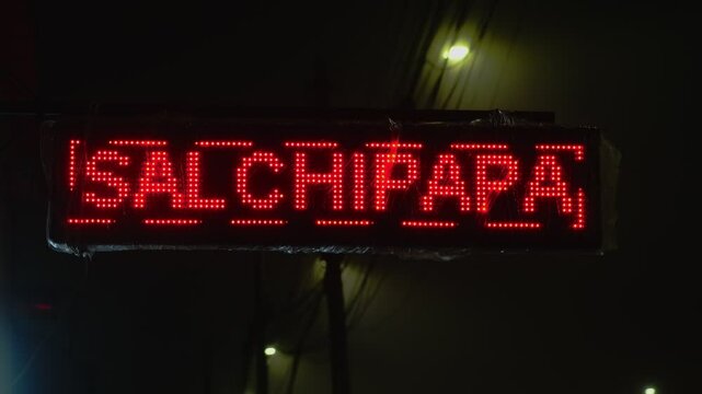 Led display sign promoting food and drinks in spanish at night