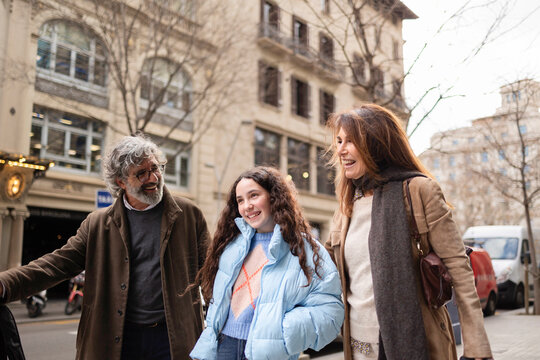 Happy family walking and smiling in urban city street