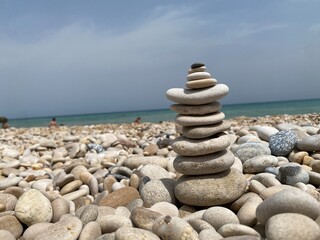 Balanced white stones carefully arranged on rocky shoreline, creating zen-like composition near Ortona coastal landscape