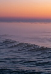 Obraz premium Pink and Purple Sunset over Misty Ocean Waves