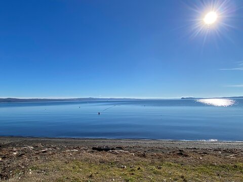 Sunlight reflecting on calm Lake Bolsena waters, framing tranquil landscape near Gradoli in scenic Latium, central Italy